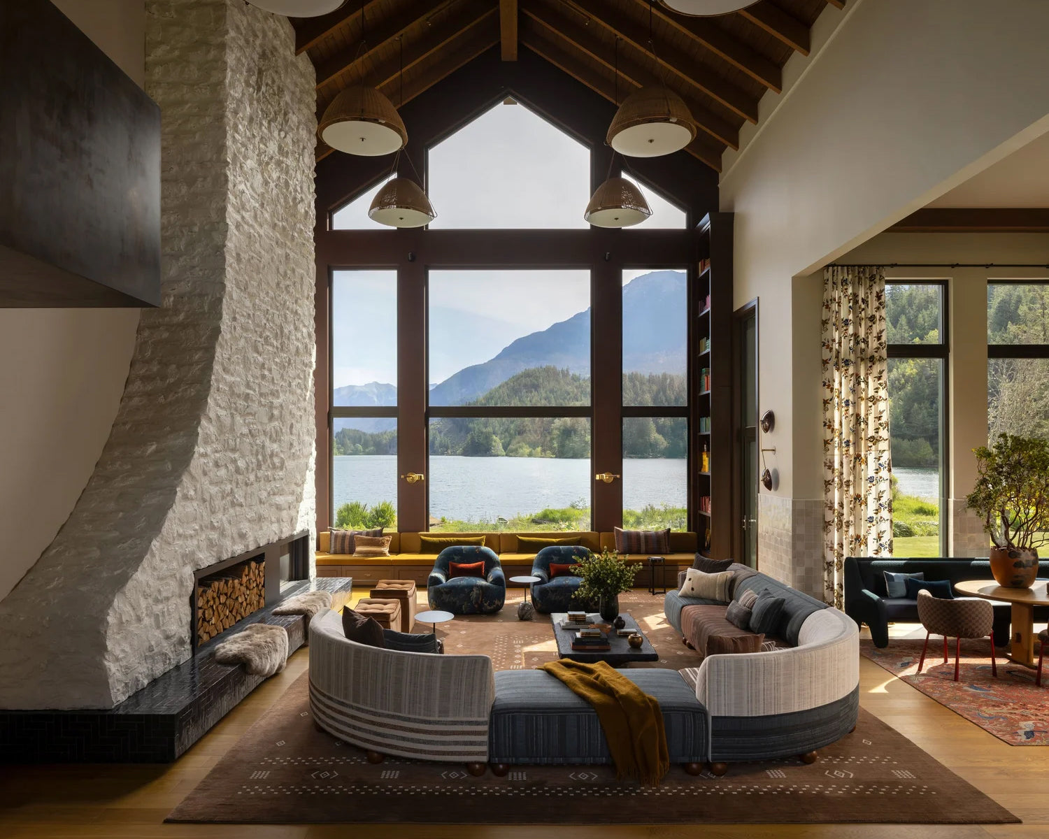 Modern living room with large windows overlooking a lake and mountains